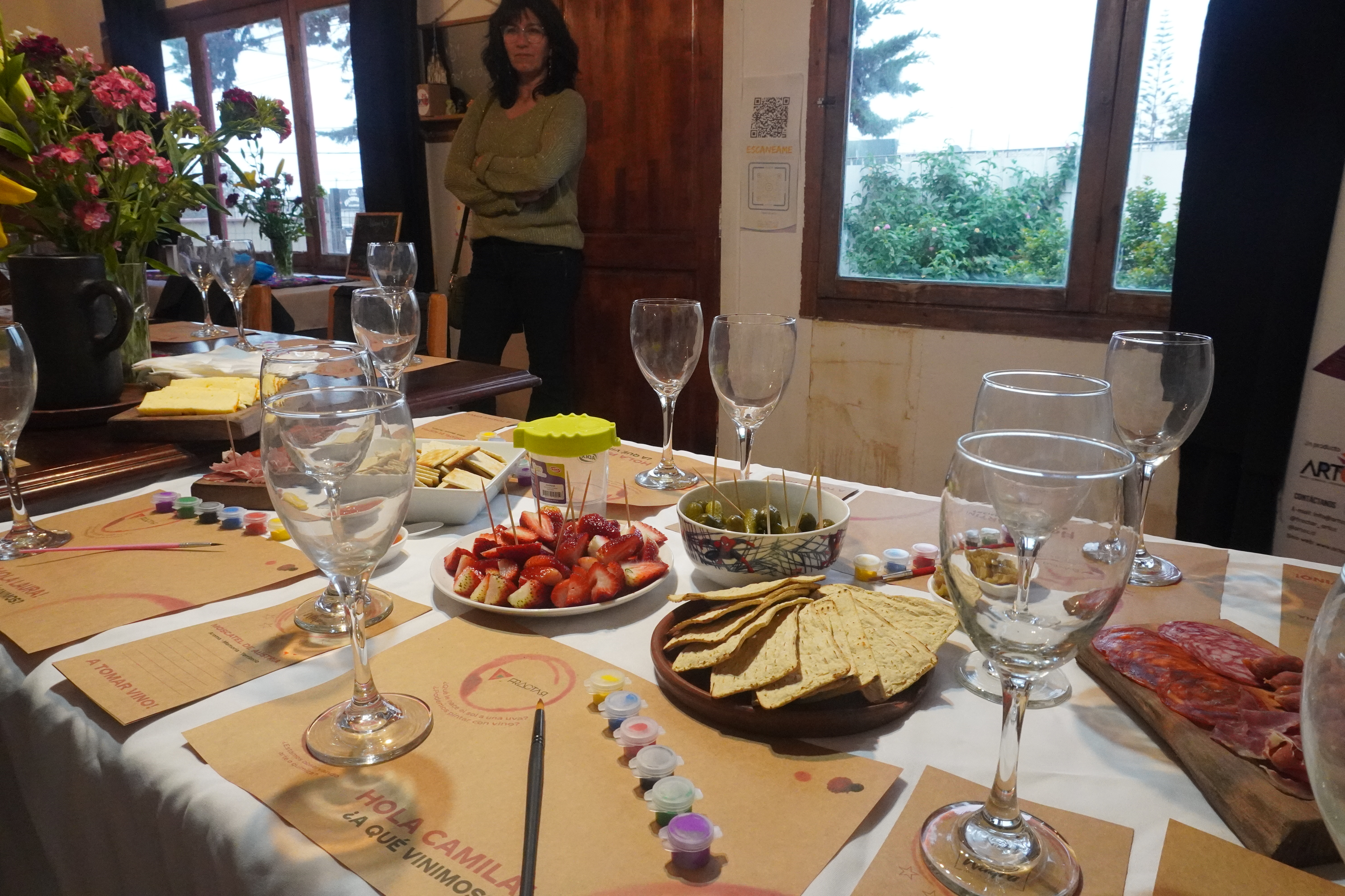 Mesa con copas, alimentos, pinceles y recipientes de pintura